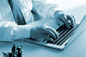 Ein Mann arbeitet im Büro an einer Laptop