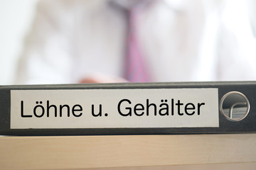 Ein Mann und Ordner mit dem Aufdruck Löhne und Gehälter