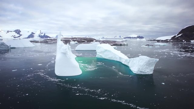 Antarctica aerial of large icebergs dark water