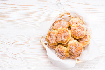 Ready-to-eat cottage cheese cookies in a basket on a wooden table. Top view