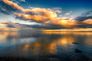 Fototapeta na wymiar Fantastic Sunset Clouds over Ocean with Reflections