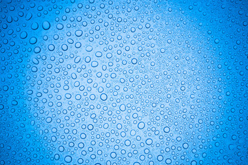 Rain droplets on blue glass background, Water drops on glass.