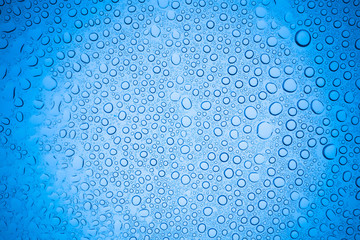 Rain droplets on blue glass background, Water drops on glass.
