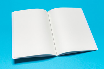 Blank paper notebook on blue background.