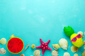 summer vibrant blue  backdrop with sea shells and bright squishy toys frame, top view copy space
