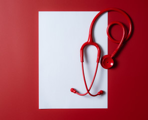 Red stethoscope and paper record on red background,Concept healthcare with space for your text