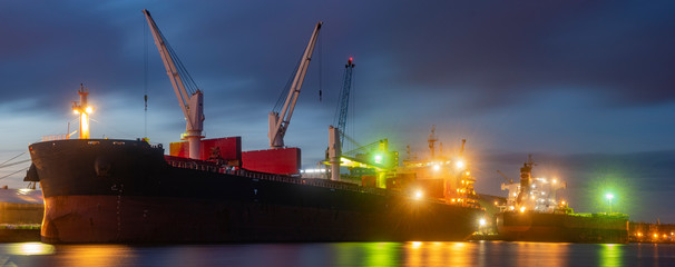 bulk cargo ships in the harbor at night