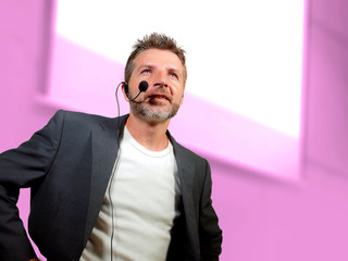 confident successful man with headset speaking at corporate business coaching and training...