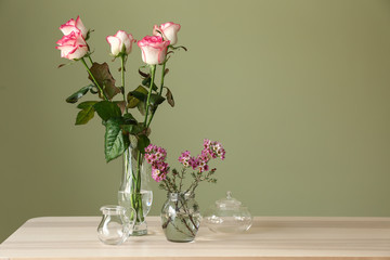 Beautiful flowers on table against color background