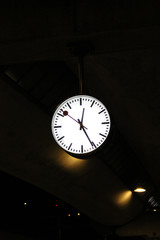 Dark scene with mysterious big clock somewhere at the train station