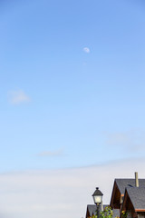 Background image of the moon with houses in a foreground corner