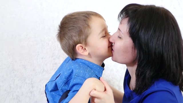 Happy family: mother and son. Mum kisses the child close up. Emotions of joy and happiness.