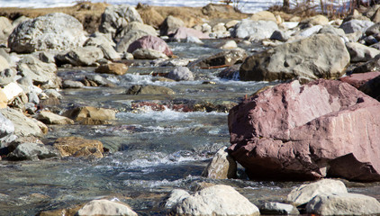 Clear water mountain river featuring a red stone