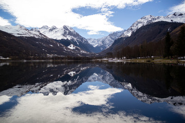 Fototapeta na wymiar Snowy mountains reflecting in the calm mirror of a lake