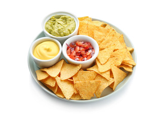 Plate with tasty nachos and sauces on white background