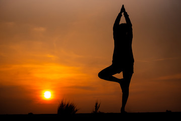 Silhouette Asia woman yoga on sunset. - Image