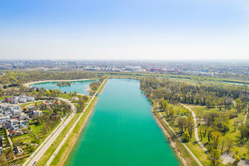 Zagreb, Croatia, Jarun lake, beautiful green recreation park area, sunny spring day, panoramic view from drone, city in background