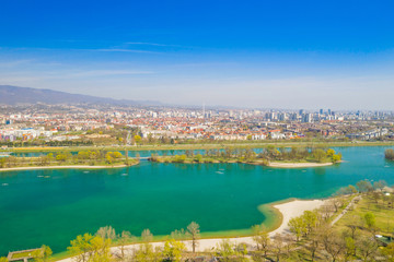 Zagreb, Croatia, Jarun lake, beautiful green recreation park area, sunny spring day, panoramic view from drone, city in background