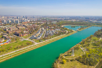 Zagreb, Croatia, Jarun lake, beautiful green recreation park area, sunny spring day, panoramic view from drone, city in background