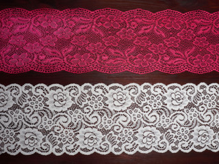 Pink and white lace on dark brown wooden background