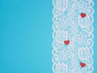White wide lace on a blue background with a red heart
