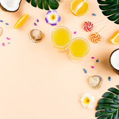 Colorful summer concept flat lay with fresh juice, tropical fruits, lollipops and multicolor seashells, copyspace