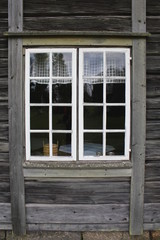 A window on a old grey wooden house in Sweden