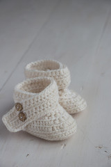 Newborn baby booties, beige, cozy and nice. Child clothe and boots - knitted and sweet. Text space, copy past and place for your design