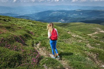 Naklejka na ściany i meble woman traveler, girl with backpack in walking mountains summer outside