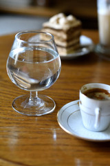 Glass of water with espresso in cafe