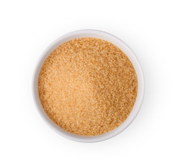 Brown refined sugar in bowl on white background.