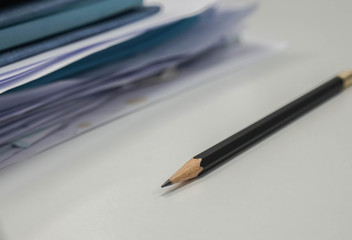 Fototapeta premium selective focus sharp pencil with business documents pile on office desk