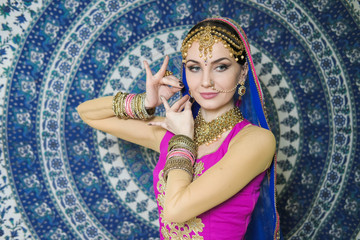 Woman in indian clothes dancing belly dance. Young beautiful woman in national costume dancing tribal dance.