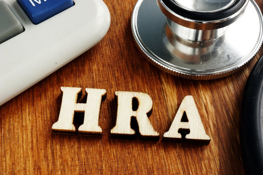 Health Reimbursement Account HRA wooden letters on desk.