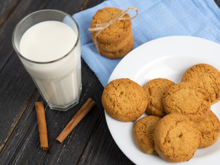 Oatmeal cookies with milk on wooden background
