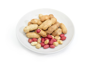 Partly peeled roasted peanuts on a white saucer
