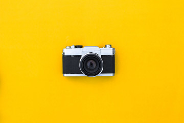 Flat lay black vintage camera and film on yellow paper background - Powered by Adobe