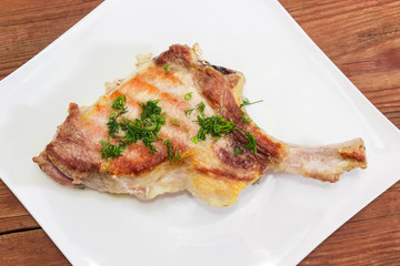 Top view of grilled pork loin on bone on dish