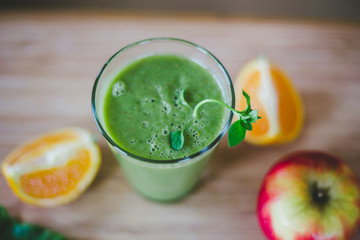 Good morning: Fresh green smoothie and fruits on wooden background, healthy breakfast