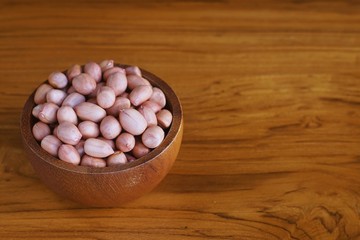Peanut in wooden bowl on classic wooden table background, peanut butter