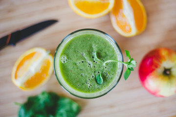 Good morning: Fresh green smoothie and fruits on wooden background, healthy breakfast