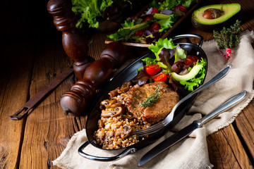 Pork steak with mushrooms and buckwheat groats and mango salad