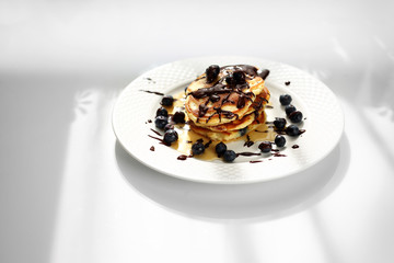 Pancakes with blueberries and maple syrup. Sweet breakfast.