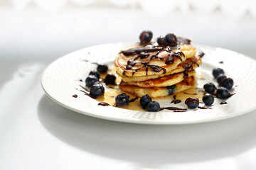 Pancakes with blueberries and maple syrup. Sweet breakfast.