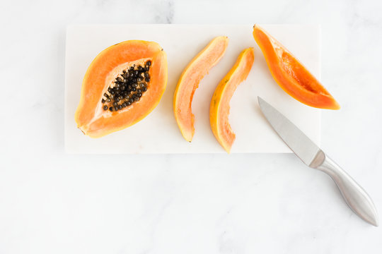 Cut Papaya on White Marble Board and Background