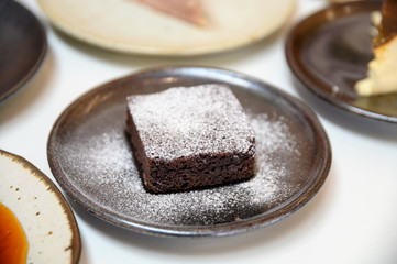 Chocolate brownie with icing powder on dish