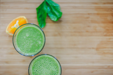 Good morning: Fresh green smoothies and fruits on wooden background, healthy breakfast. Text space.