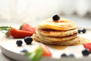 Sweet breakfast. Pancakes with strawberries, blueberries and maple syrup. Sweet breakfast.
