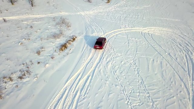 Red retro car drift on a field in the snow