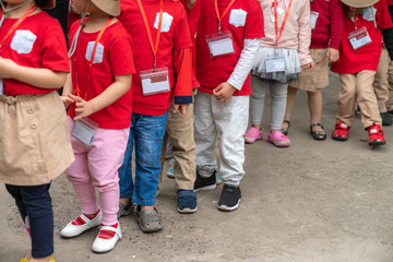 Queue of Asian kids in school uniform standing in line